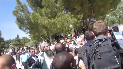 Cientos de musulmanes en el Monte del Templo, gritando y arrojando objetos, rodean a tres judíos y a sus hijos, mientras una docena de policías tratan de contener a la multitud y evacuar a los judíos.