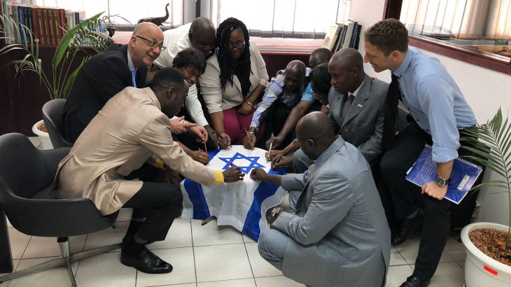 Oficiales de Abidjan firman una bandera de Israel